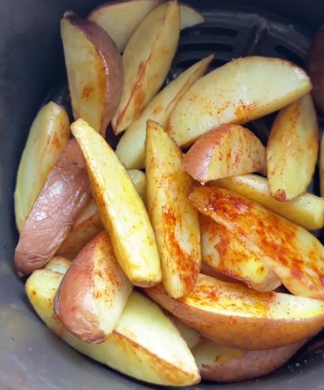 Elle enrobe les pommes de terre de paprika, d'huile, de sel et de poivre, ajoute l'eau et fait cuire.